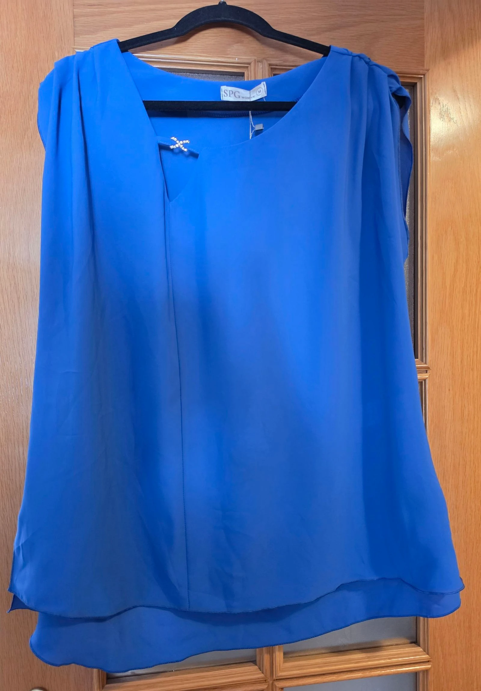 Blusa azul Klein elegante con detalle joya